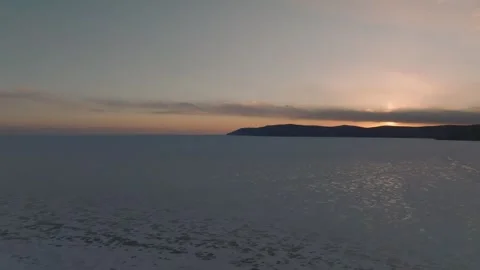 Winter sunset over Lake Baikal near Listvyanka with calm ice and horizon Stock Footage 334102030