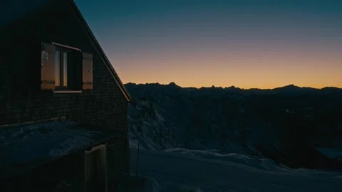 Winter Sunset over a Mountain Cabin with Golden Hour Glow in the Alps Vidéo 331170374
