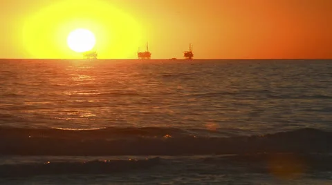 Winter sunset over the Pacific Ocean behind three oil platforms off of the Video stock 27194077