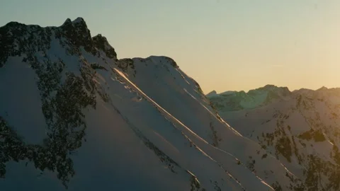 Winter Sunset over Snow Covered Mountain Peaks During Golden Hour Light Vidéo 331170304
