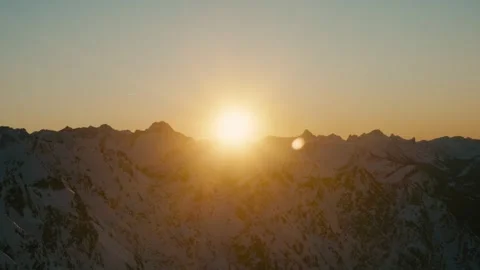 Winter Sunset over Snow Covered Mountain Peaks During Golden Hour Light 库存影片 331170347