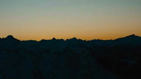 Winter Sunset over Snow Covered Mountain Peaks During Golden Hour Light Vidéo 331170364