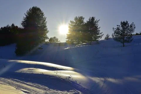 Winter sunset over snowy fields. The snow-white surface of the snow glows in  Stock Photos