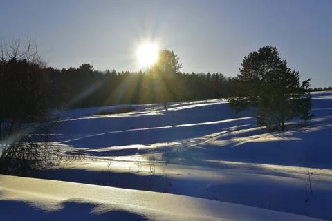 Winter sunset over snowy fields. The snow-white surface of the snow glows in  Stock Photos