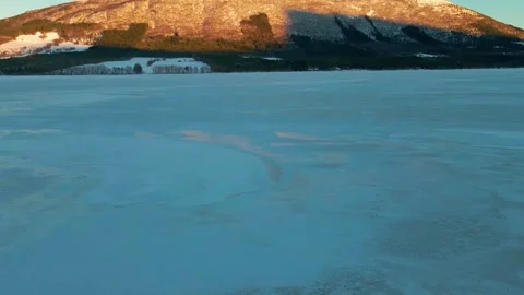 Winter Sunset over a Snowy Mountain and Frozen Lake near Bud Fishing Village Stock Footage 315795377