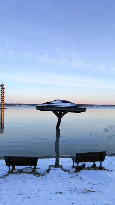 Winter sunset on the snow-covered beach of Lake Goitschesee, wooden pier and Stock Footage 327072826