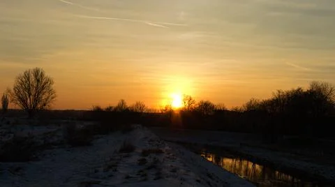 Winter sunset on the winter river. Stock Photos