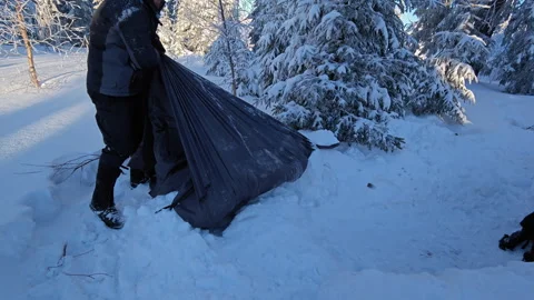 Winter Survivalist Pulling Heavy Black Tarp Shelter From Deep Snow Stock Footage 336498681