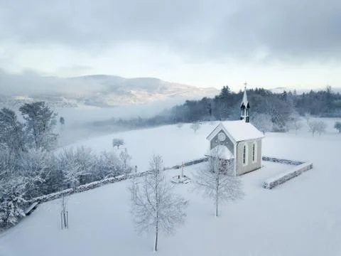 Winter Switzerland fairytale chapel on hill Stock Photos