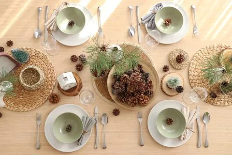 Winter table setting with pine cones and branches in room, top view Stock Photos