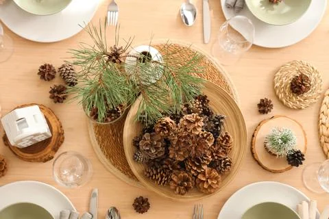 Winter table setting with pine cones and branches in room, top view Stock Photos