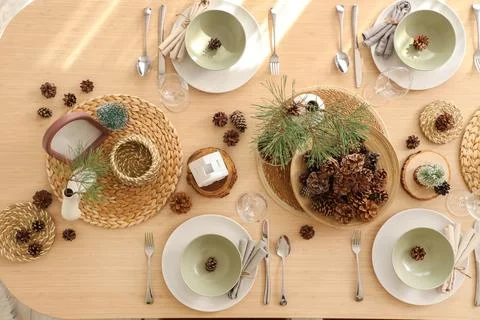 Winter table setting with pine cones and branches in room, top view Stock Photos