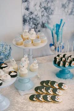 Winter-themed dessert table featuring cupcakes, cookies, and cake pops at a cozy Stock Photos
