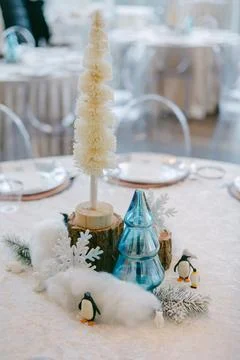 Winter-themed table decoration featuring trees, penguins, and snowflakes in a Stock Photos
