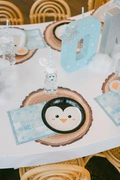 Winter-themed table setting featuring penguin plates at a festive celebration Stock Photos
