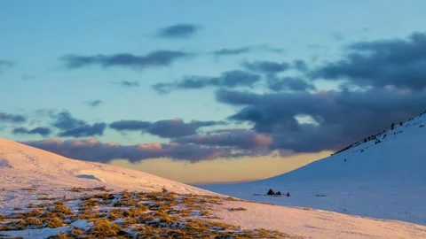 Winter time lapse in mountain environment with clouds moving between two hills Stock Footage 235728021