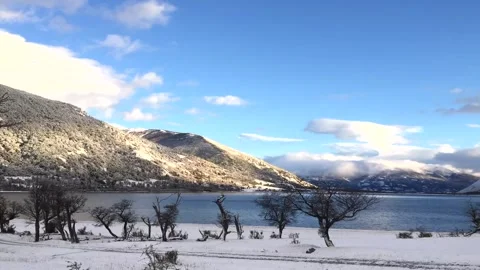 Winter time lapse of moving white clouds in a blue sky above snowy hills in Stock Footage 264808665