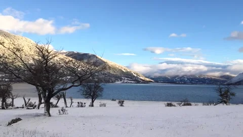 Winter time lapse of moving white clouds in a blue sky above snowy hills and Stock Footage 264808699