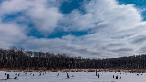 Winter time lapse of white clouds moving through a bright blue sky Stock Footage 126413078