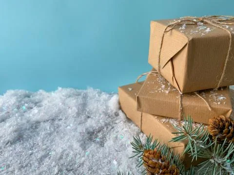 Winter time. Rustic gift box with craft paper. Christmas gift on snowy backgroun Stock Photos