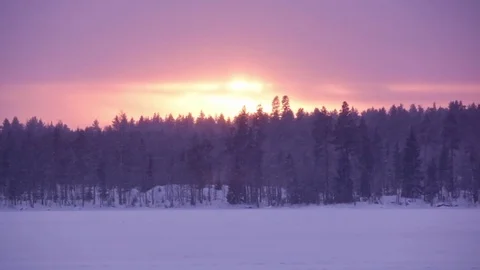 Winter timelapse of sun setting behind a forest after snowfall Stock Footage 70565993