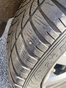 Winter tire with nail causing a flat car tire Stock Photos