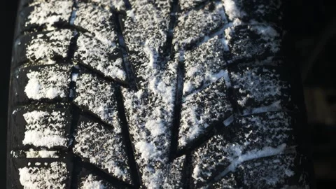 Winter tire tread close up showing snow patterns and tread design during cold Stock Footage 332820885
