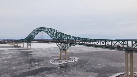 Winter traffic scene with bridge over frozen river aerial Stock Footage 329395615