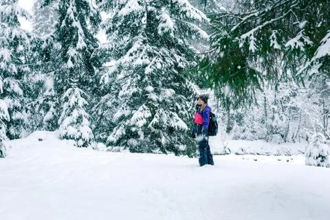 Winter travel girl with a backpack in forest Foto stock