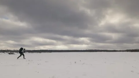 Winter Trek: Adventurous Run Across Snowy Fields Video stock 288997799