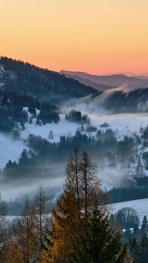 Winter valley with misty low clouds flowing over a picturesque landscape cold Stock Footage 294909691