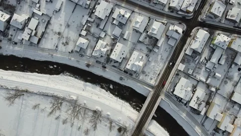 Winter vertical drone closeup - housing and bridge of small town snow covered Stock Footage 167775639