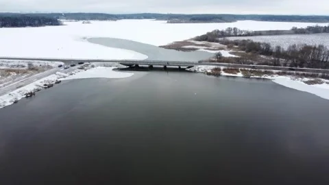 Winter view of a bridge over a river with snow and ice in the surrounding area n Stock Footage 329433180