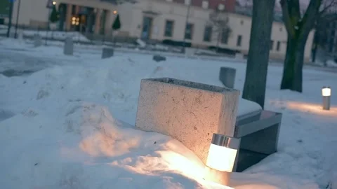 Winter view of flower pot and  glowing lamp on deserted square in city. Stock Footage