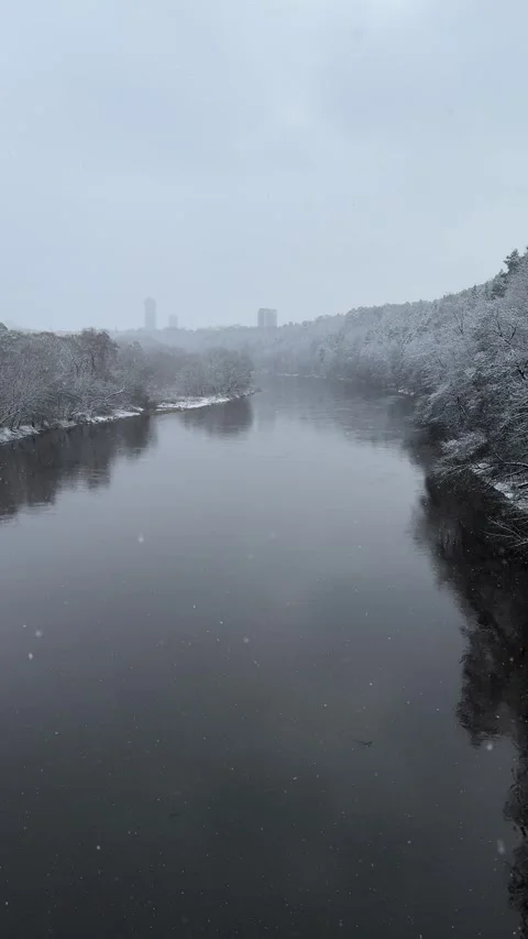 Winter view river from bridge during snowfall in Vilnius. Vertical video Stock Footage 260076921