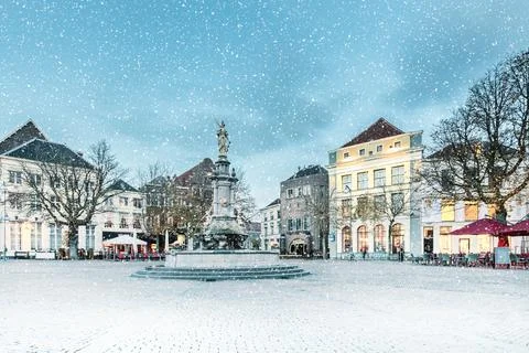 Winter view with snowfall of the central square in the historic Dutch city De Stock Photos