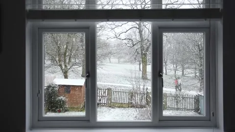 Winter view from a window - people in ski jackets walking in the snow in the Stock Footage 147282189