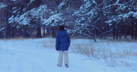 Winter walk in the forest, a young man walks along a snowy path. View from the Stock Footage 123183035