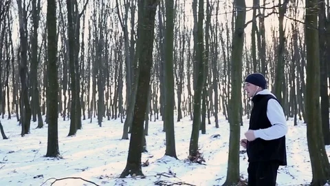 Winter walk - a young man walking in the park, listening to music with Stock Footage 77059618