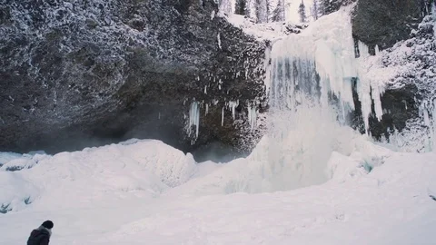 Winter Waterfall subtle pan right with person taking it in Stock Footage 71240419