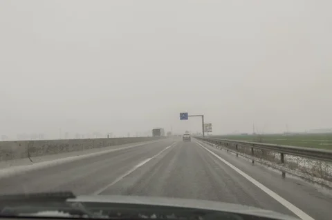 Winter weather on the car road - falling snow Stock Footage 87644917
