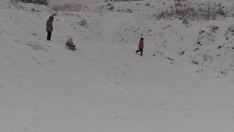 In winter, when skiing downhill on a sled, the child fell Stock Footage 73672990