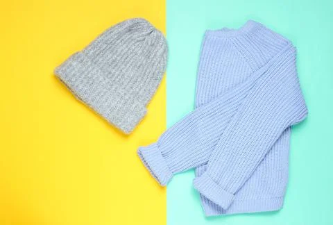 Winter woolen hat, sweater on a colored paper background, minimalism, top vie Фото