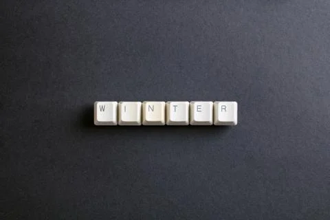 Winter word is written with computer keys button on a dark background. Foto stock