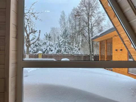 Winter yard through triangular window in wooden cabin, Belarus forest Stock Photos