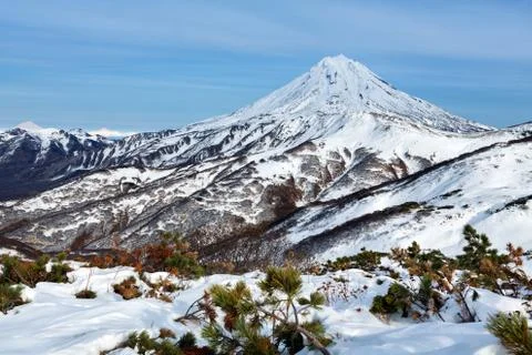 Wintry mountainous landscape - snow-capped cone of volcano Stock Photos