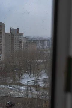 Wintry view through window over Soviet era apartment blocks and snow Stock Photos