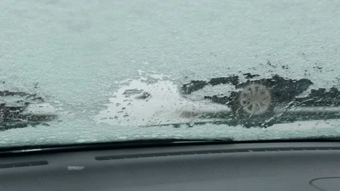 Wiper clearing ice patch on windshield leaving streaks and revealing partial Stock-Footage 327825118