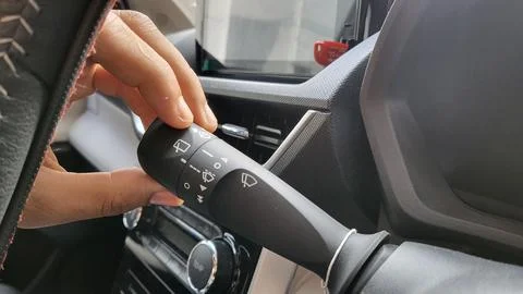 Wiper control button, An Asian man's hand is operating the wiper switch of .. Stock Photos