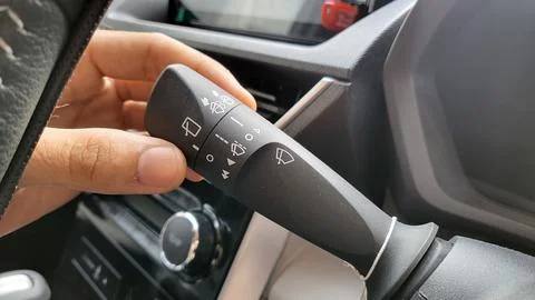 Wiper control button, An Asian man's hand is operating the wiper switch of .. Stock Photos